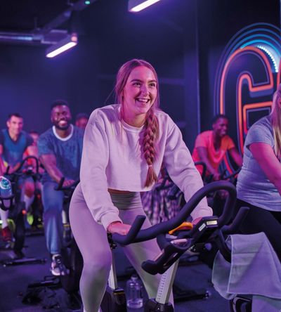 A class session where gyms users are doing cardio workout on an exercise bike.